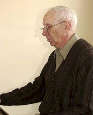 Stan Farrow in front of a piano