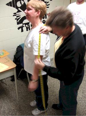 Barb Farrow measures Wanita with a measuring tape