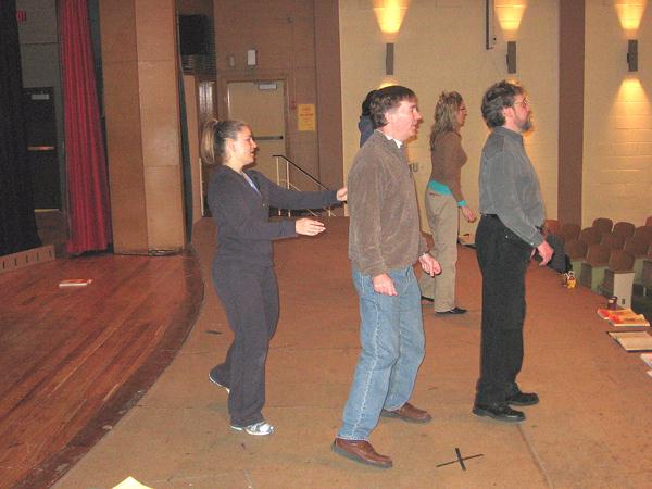 A side shot of Debbie physically directing the leads on stage