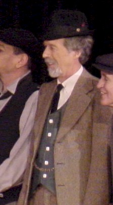 Felix in a brown suit costume with a smile.