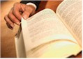 Photo of hand turning the page of a book